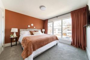 a bedroom with a large bed and a large window at Chic Hideaway - King Bed - Fireplace - Garage - AC - DT and WEM in Edmonton +58 photos