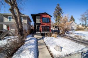 a home with a red house in the snow at Chic Hideaway - King Bed - Fireplace - Garage - AC - DT and WEM in Edmonton
