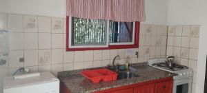 a kitchen with a sink and a red bowl at Luna Plateada - Terrafirme in Villa Yacanto +43 photos