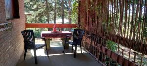 a table and two chairs sitting on a porch at Luna Plateada - Terrafirme in Villa Yacanto