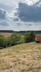 a yellow truck parked in a field with trees at Maringotka na kopečku in Kotaneč