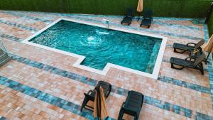 an overhead view of a swimming pool with chairs and umbrellas at Villa Dubrava in Matuzići