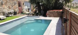 a blue swimming pool in a yard with a fence at Casa Agustín Pool 27 ºC in Fátaga