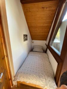 a bed in a small room with a window at Gasthaus Liam 4 in Bendorf +2 photos