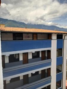 a blue and white building with mountains in the background at Oviedo Hotel R in Mérida