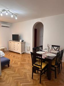 a dining room with a table and chairs and a television at Sirius Apartment in Škaljari