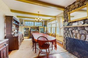 a dining room with a table and a stone wall at Andrews Point Ocean Home in Rockport +51 photos