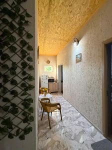 a room with a wall covered in fake plants at Dadu's Guesthouse in Samtredia