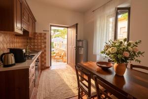 a kitchen with a table with a vase of flowers on it at Macri Alghero in Alghero