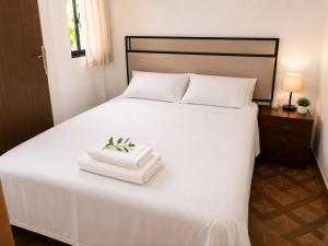 a white bed with two towels on top of it at Aparta Suites Torre de Prado 502 Apartamento para 5 Personas in Medellín