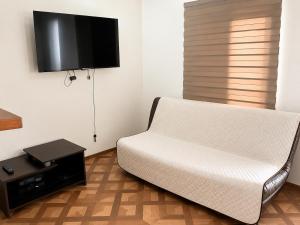 a living room with a white couch and a flat screen tv at Aparta Suites Torre de Prado 502 Apartamento para 5 Personas in Medellín