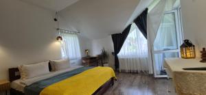 a bedroom with a bed and two large windows at GONTA kottage - БАСЕЙН,ЧАН - Джакузі in Slavske +51 photos