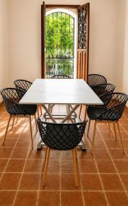 a white dining table with chairs and a window at Tángara Home in Cali