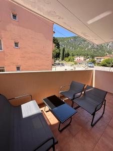 a room with two chairs and a table on a balcony at Sirius Apartment in Škaljari