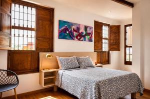 a bedroom with a bed and a painting on the wall at Tángara Home in Cali