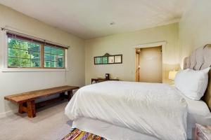a bedroom with a bed and a bench and a window at Riverside Bliss in Bellevue