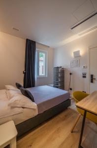 a bedroom with a bed and a table and a window at Dimora in Prato in Padova