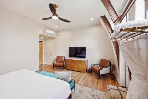 a bedroom with a bed and a living room with a television at The Q Inn in Morro Bay