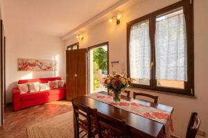 a living room with a table and a red couch at Macri Alghero in Alghero