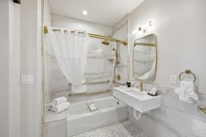a white bathroom with a sink and a mirror at The Q Inn in Morro Bay +56 photos