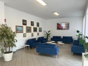 a waiting room with blue couches and plants at Hotel Primula in Lido di Savio