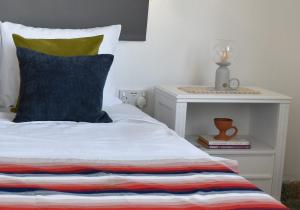 a bed with a colorful striped pillow and a side table at Stone Suites in Famagusta