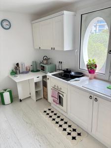 a kitchen with white cabinets and a window at New,mountain & sea view 3 guests with private Garage in Beausoleil