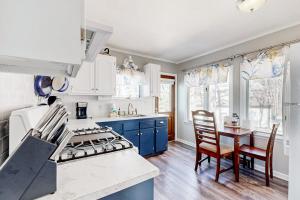 a kitchen with a stove and a table with chairs at Main House in Ossipee