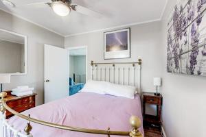 a bedroom with a bed with a pink bedspread at Main House in Ossipee