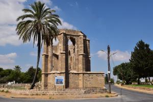 an old building with a palm tree next to a street at Stone Suites in Famagusta