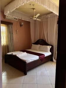 a bed in a bedroom with a ceiling fan at Barizi Cottage in Tulu