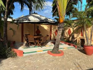 a table and chairs under an umbrella on a patio at Barizi Cottage in Tulu