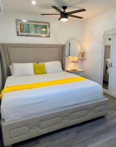 a bedroom with a large bed with a ceiling fan at Private Cozy Studio in Sunrise