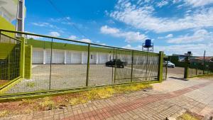 a fence in front of a parking lot at Kitinete Mobiliada in Chapecó