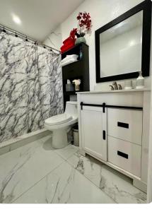 a bathroom with a toilet and a marble shower curtain at Private Cozy Studio in Sunrise