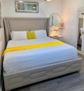 a bedroom with a large bed with a yellow blanket at Private Cozy Studio in Sunrise +2 photos