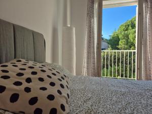 a bedroom with a bed with a pillow and a window at Otto Novalja, spacious penthouse apartment in city center in Novalja