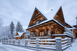 a log cabin in the snow at Villa Alexandra jacuzzi in Kościelisko