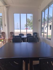 a meeting room with tables and chairs and windows at Aimers Lodge in Dungun