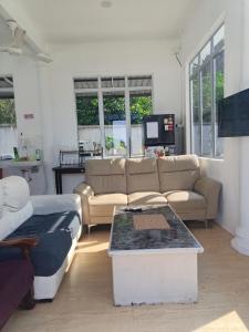 a living room with two couches and a table at Aimers Lodge in Dungun