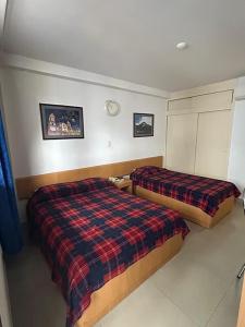 a bedroom with two beds and a clock on the wall at Oviedo Hotel R in Mérida +8 photos