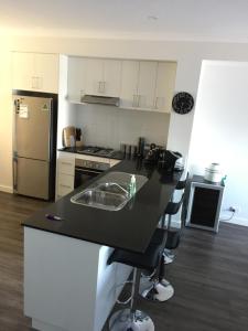 a kitchen with a counter with a sink and a refrigerator at Falcon Bay 4x4 Townhouse in Wannanup