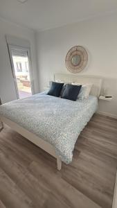 a white bedroom with a bed with blue pillows at Blessed House in Portimão