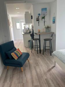 a living room with a blue chair and a kitchen at Blessed House in Portimão