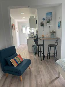 a living room with a blue couch and a kitchen at Blessed House in Portimão