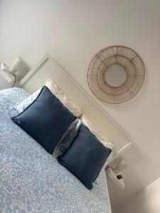 a bedroom with a bed with blue pillows and a mirror at Blessed House in Portimão
