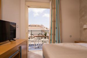 a hotel room with a bed and a view of a balcony at Plaza Hotel in Zakynthos