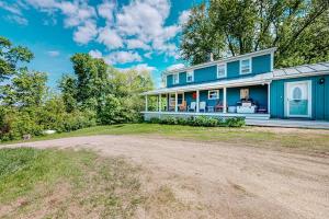 a blue house with a dirt road in front of it at Town Farm Retreat in Ludlow