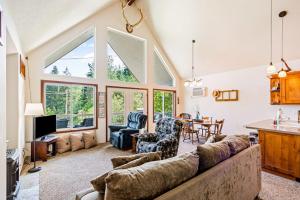 a living room with a large couch and a table at Garfield Bay View Home in Sagle