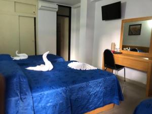 a bedroom with a blue bed with a swan on it at Oviedo Hotel R in Mérida